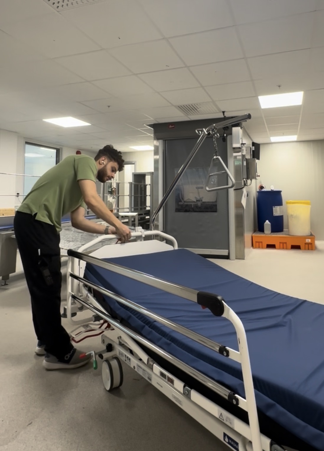 Nezar Naser bäddar en sjukhussäng under ett skift som sjuktransportör på Kungälvs sjukhus