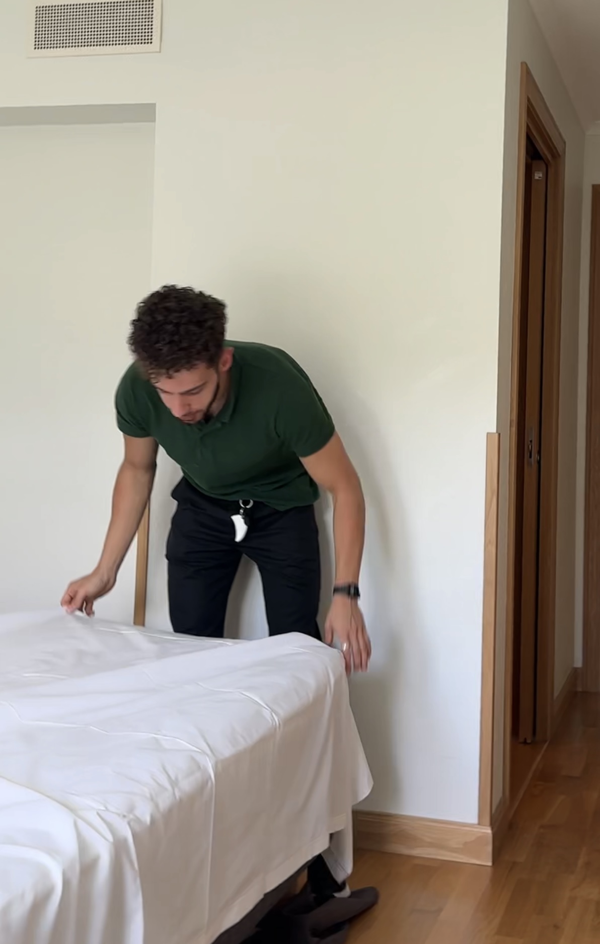 Nezar Naser bäddar en säng under ett städskift på hotell